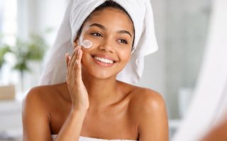 femme-souriante-creme-visage-miroir