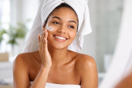 femme-souriante-creme-visage-miroir